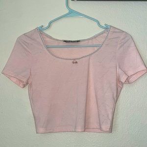 cute pink crop top with bow accent.
